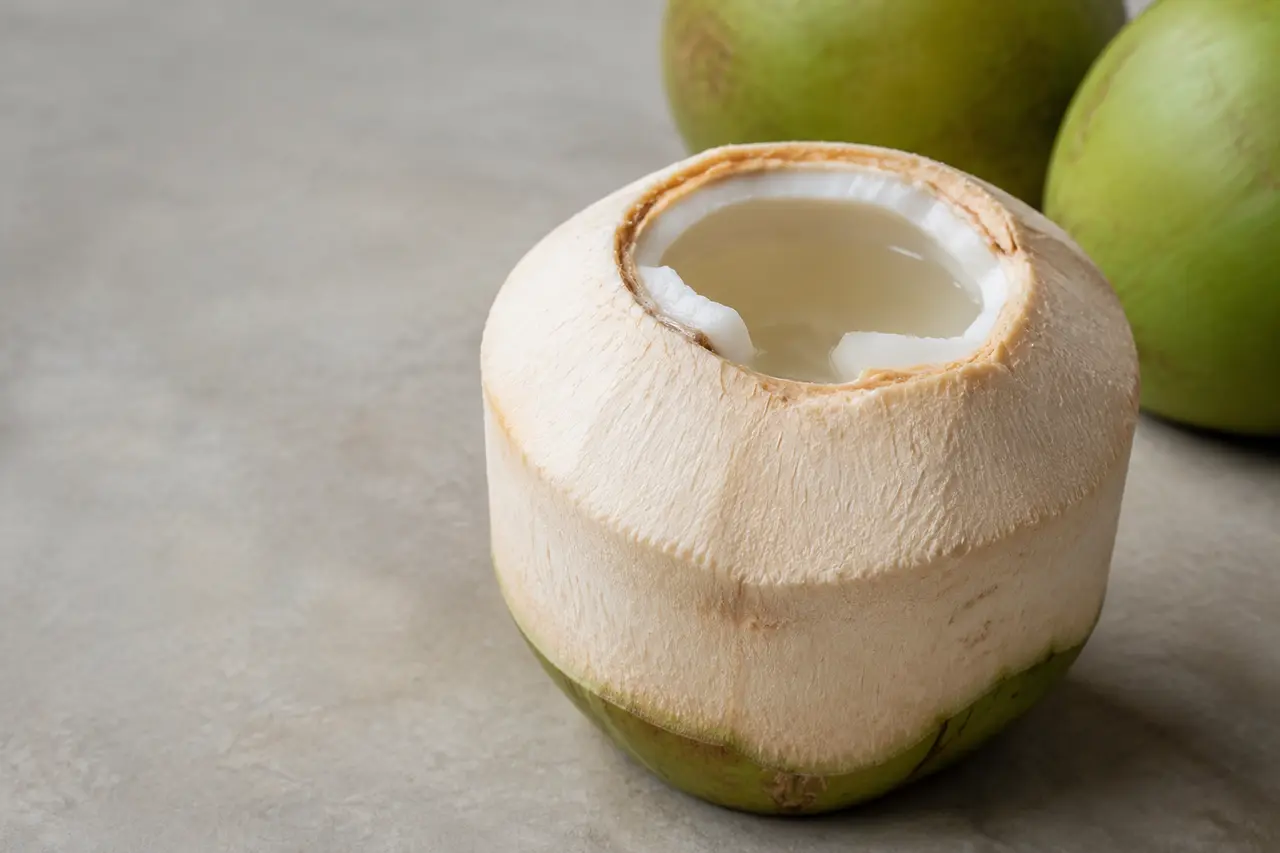 Opened Thai Nam Hom coconut showing clear water and tender young flesh